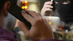 Telefonický podvod, muž hovorí s podvodníkom v maske cez telefón
